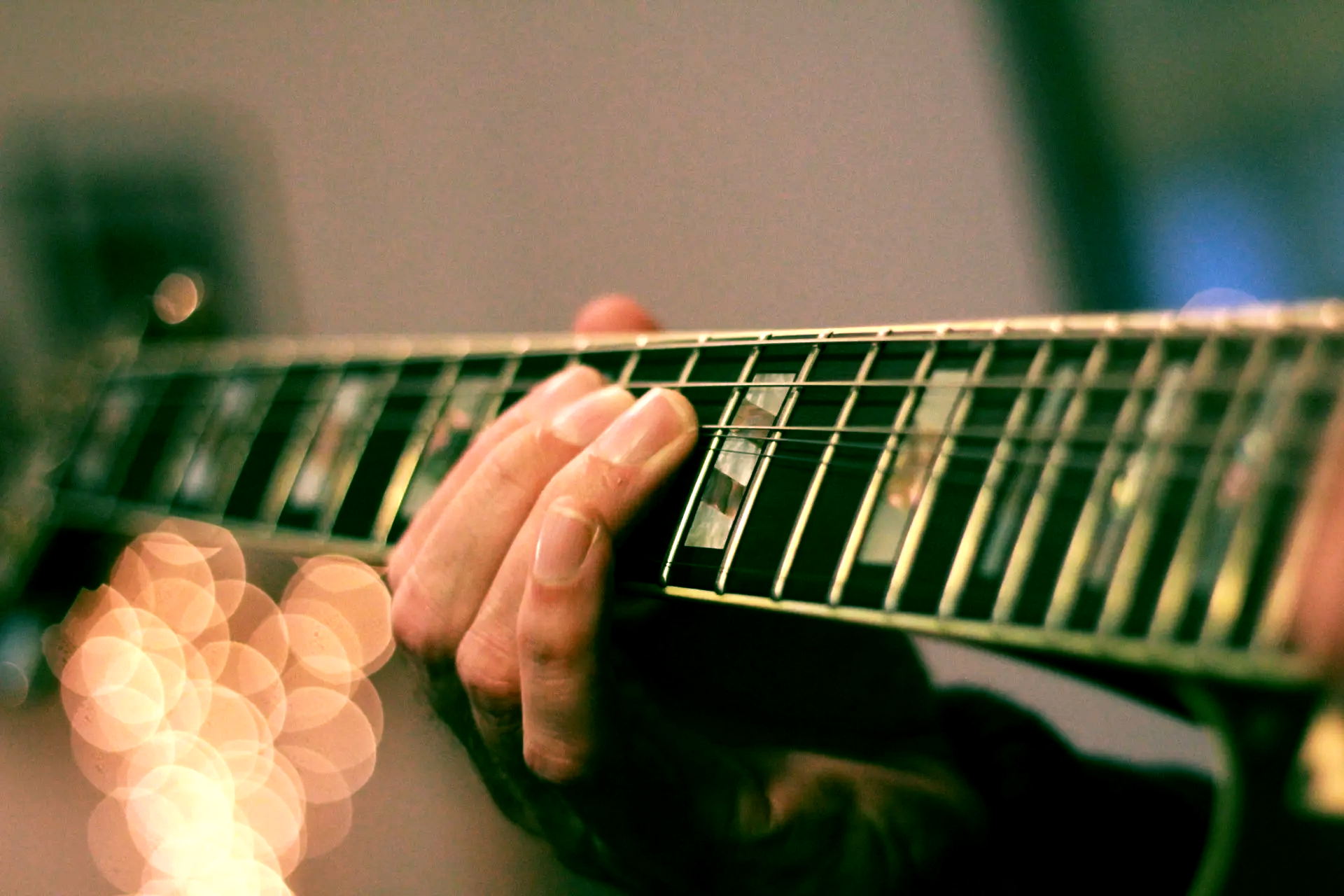 A guitarist's hand on a guitar fretboard