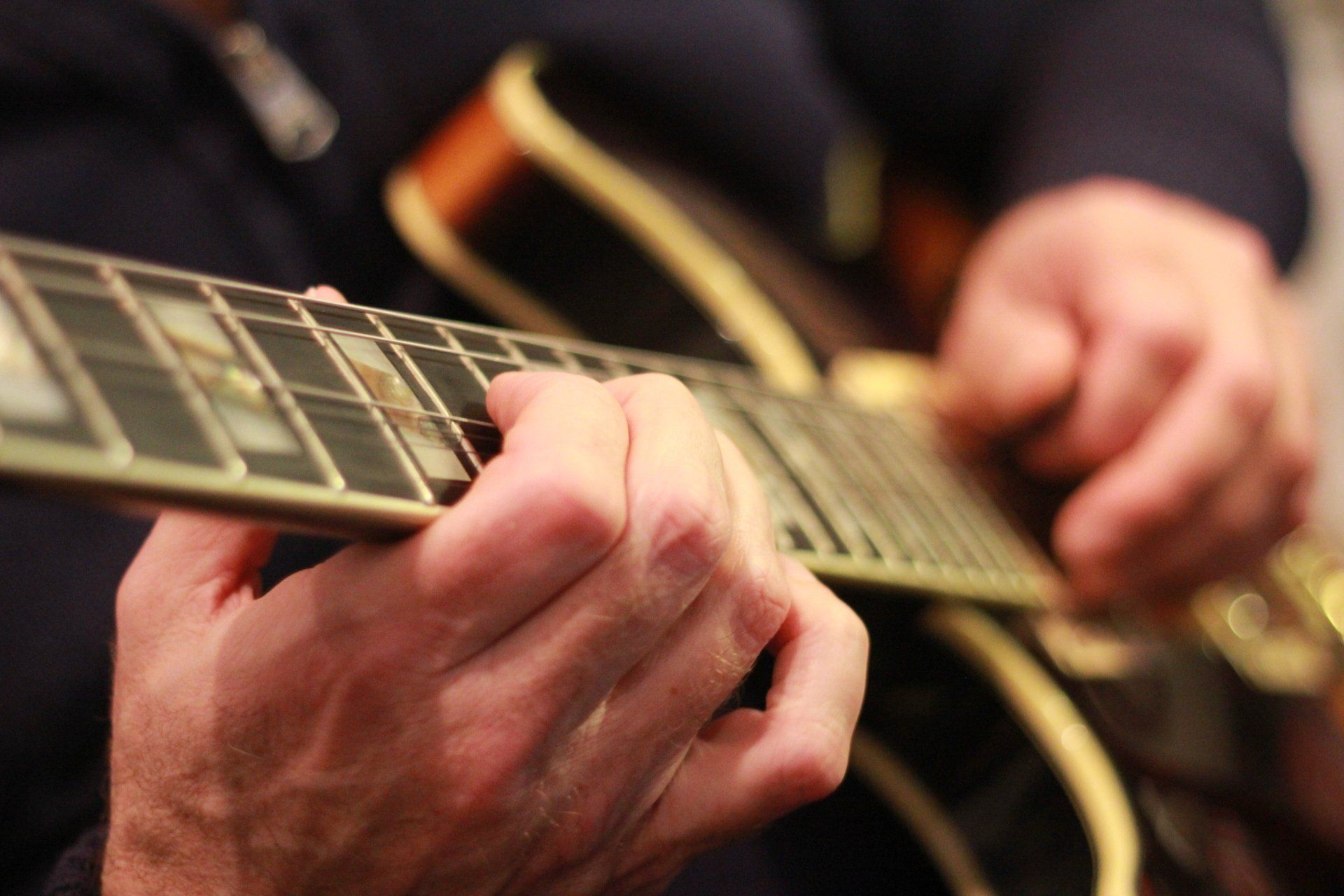 A guitarist's hand on the fretboard
