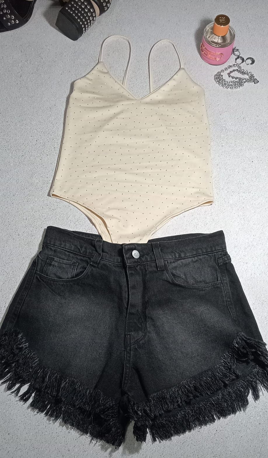 Atuendo: Body beige y shorts vaqueros negros con flecos. Accesorios: zapatos, perfume y joyas.