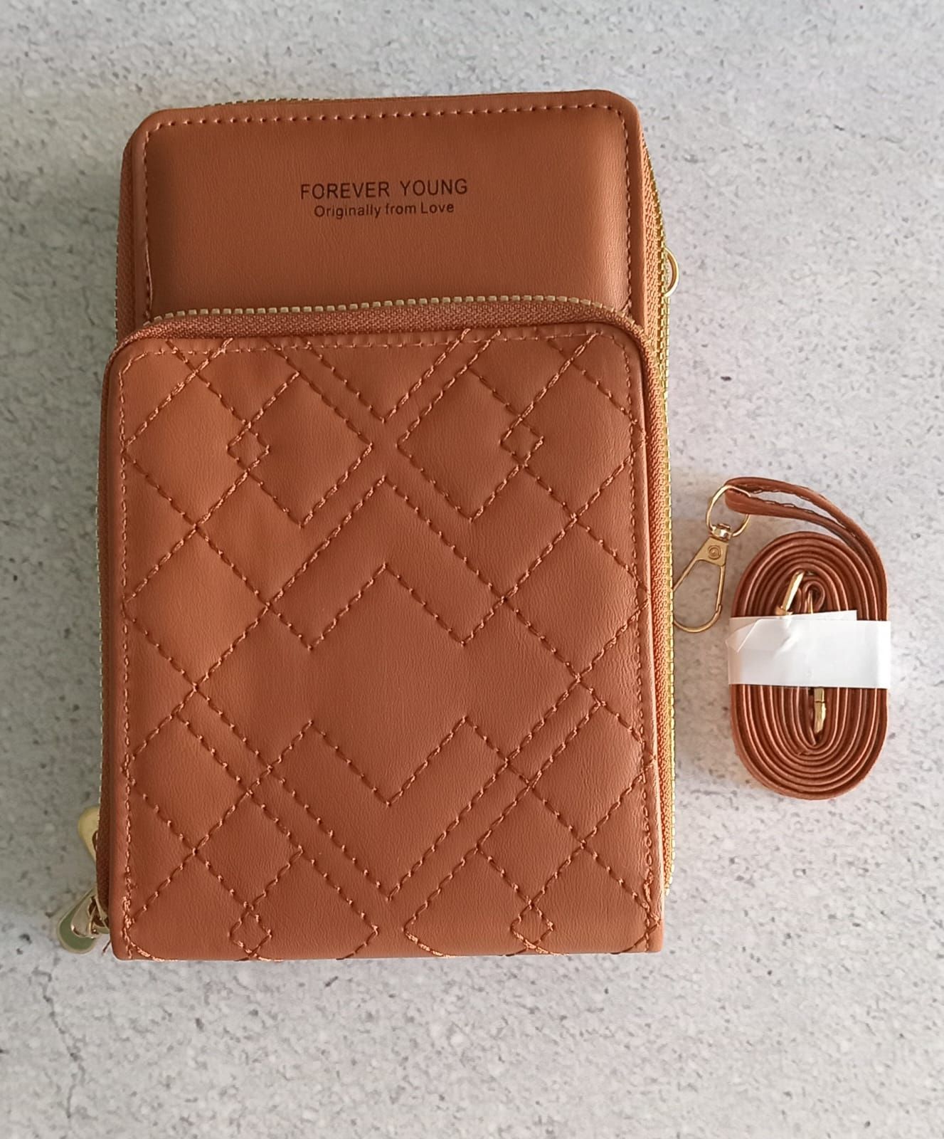 Bolso bandolera acolchado de color marrón con correa adjunta.