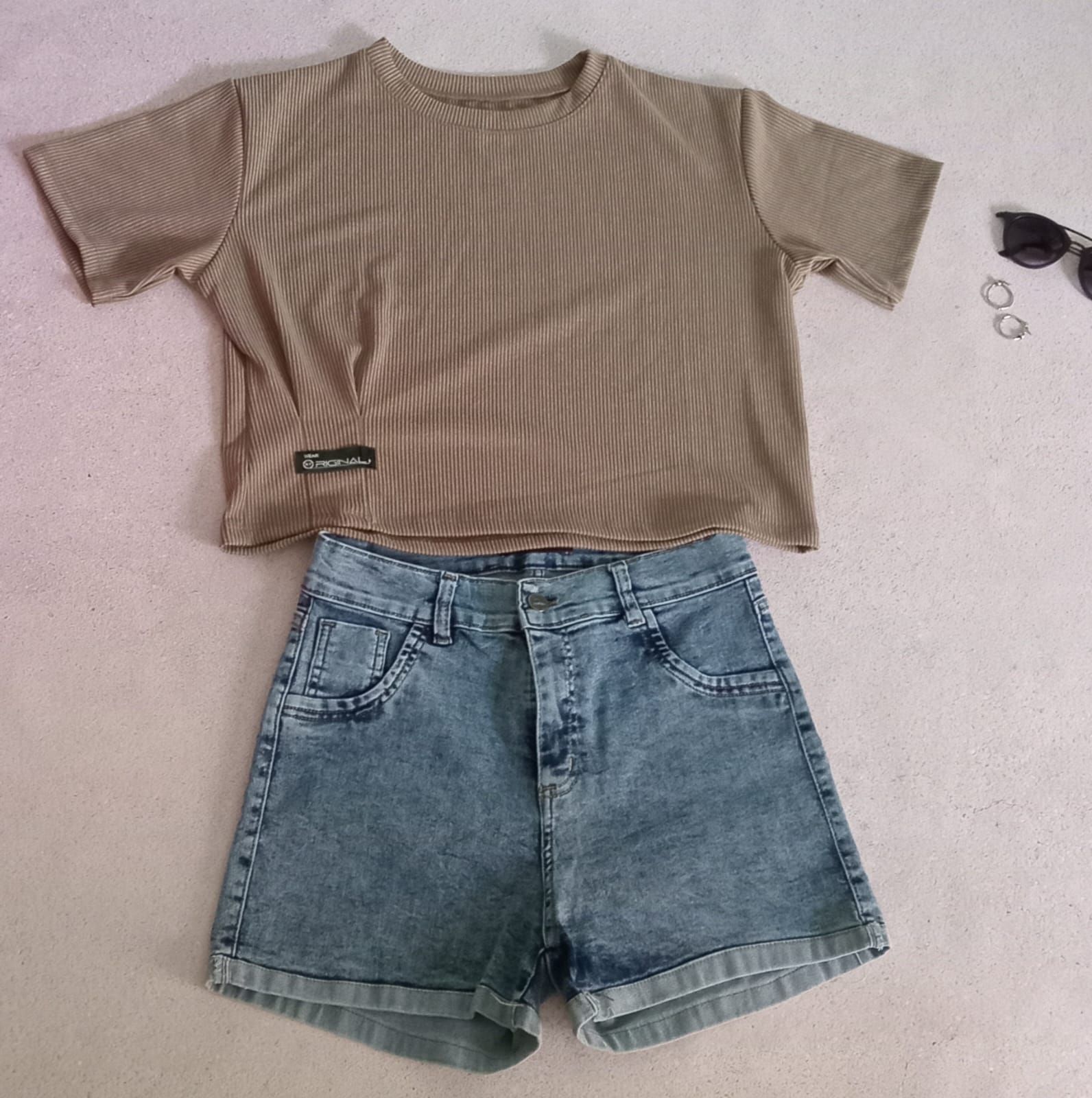 Top corto de canalé color canela y shorts vaqueros, con la parte superior plana. Gafas de sol y pendientes junto al top.