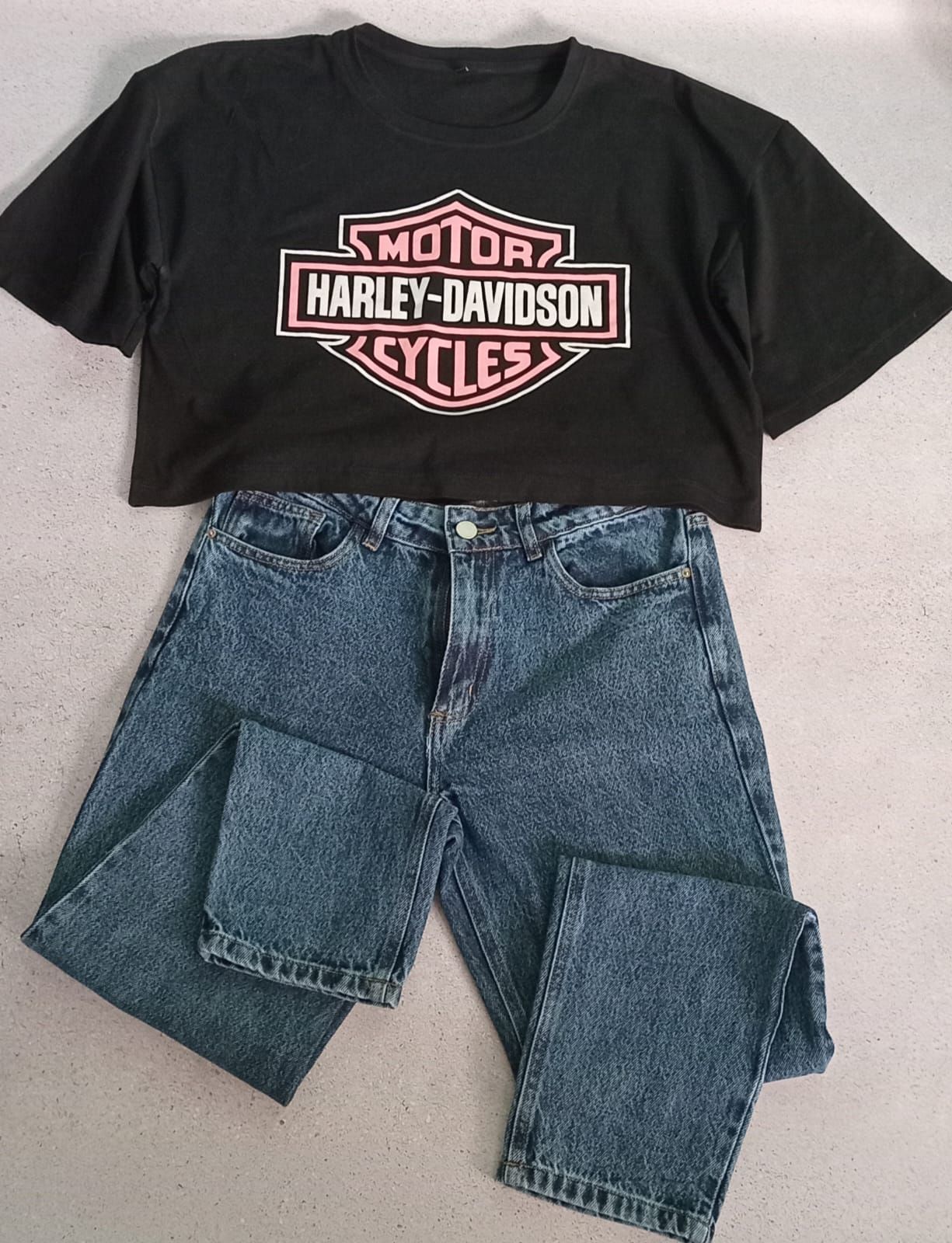 Crop top Harley-Davidson negro con logo, combinado con jeans azules.