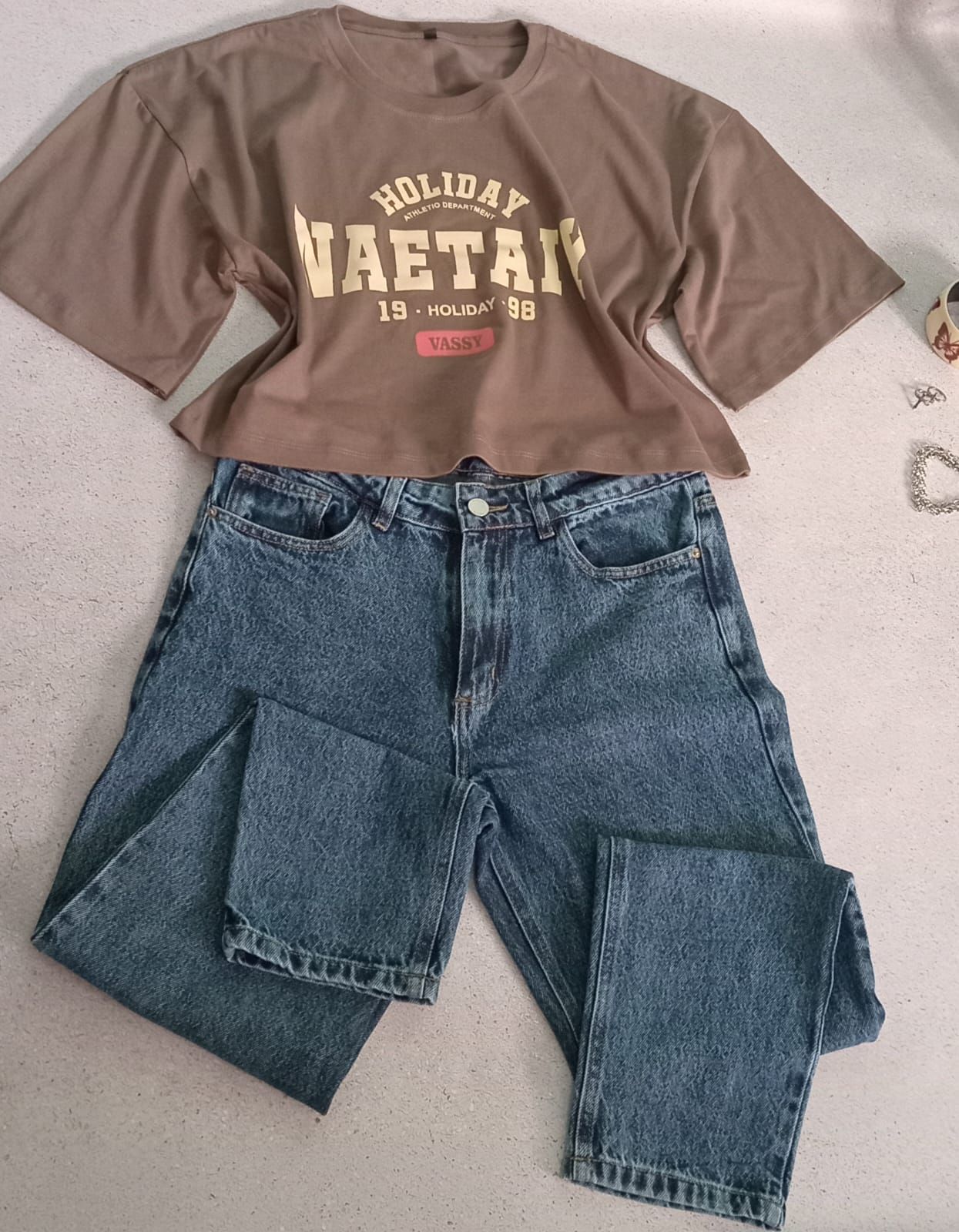 Tres camisetas: negra, blanca y marrón. Cada una tiene un logotipo. La camiseta negra dice 