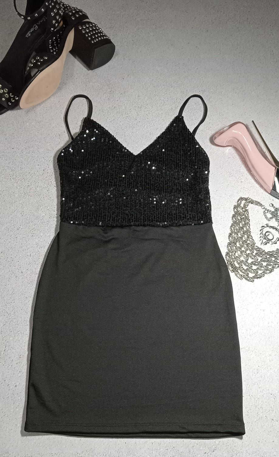 Vestido mini con corpiño de lentejuelas negras y tirantes finos.