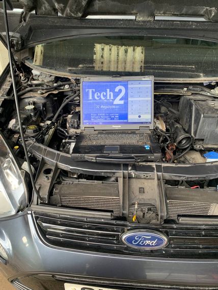 technician analyze the car's engine graph on laptop computer in the garage