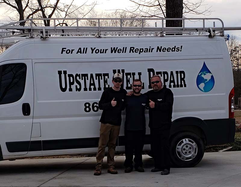 Three men by a white van with 