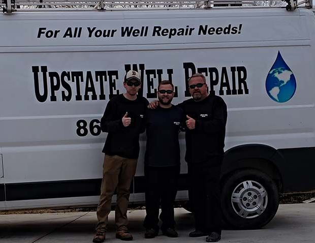 Well pump system with pressure tank and equipment exposed in an outdoor setting.