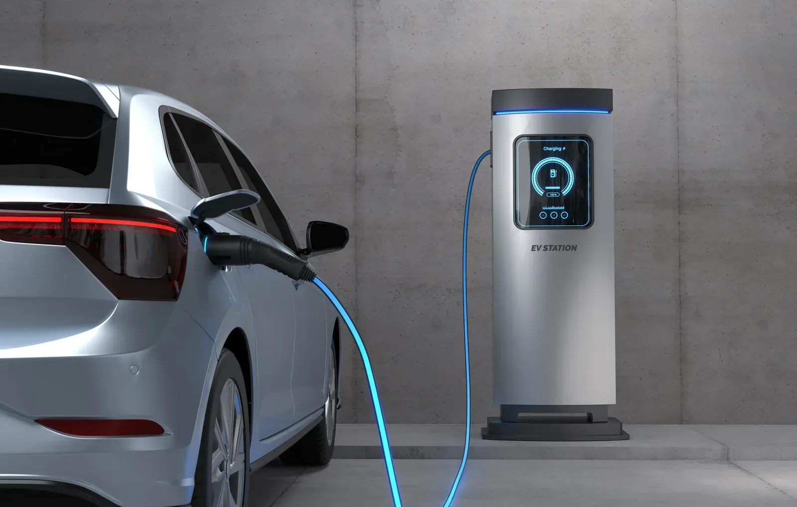 A light-colored electric car parked indoors, connected to a modern charging station by a blue cable.