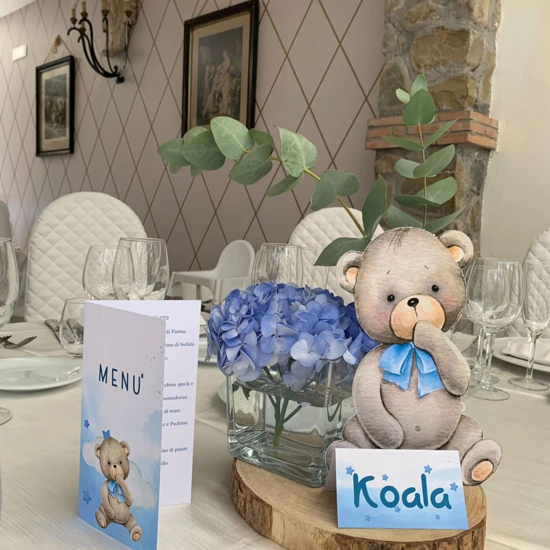 Un orsacchiotto seduto su un ceppo di legno con un cartello che dice koala