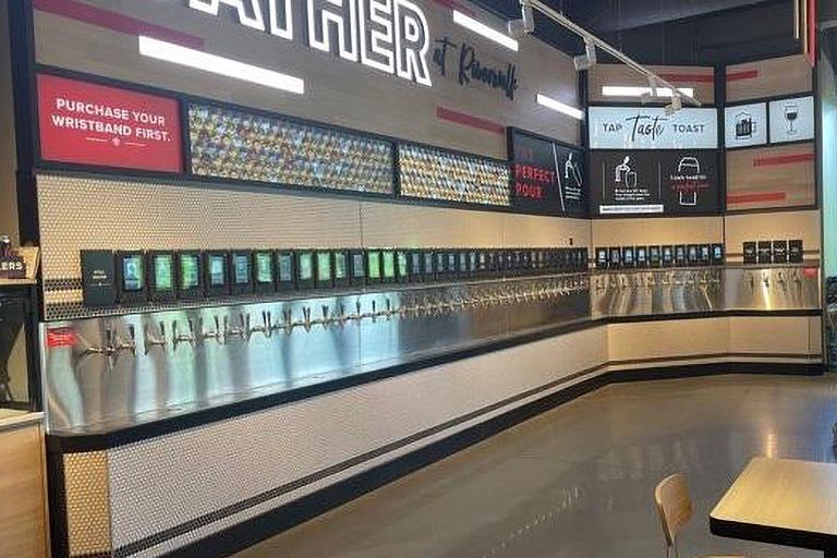 A restaurant with a lot of taps and a table.