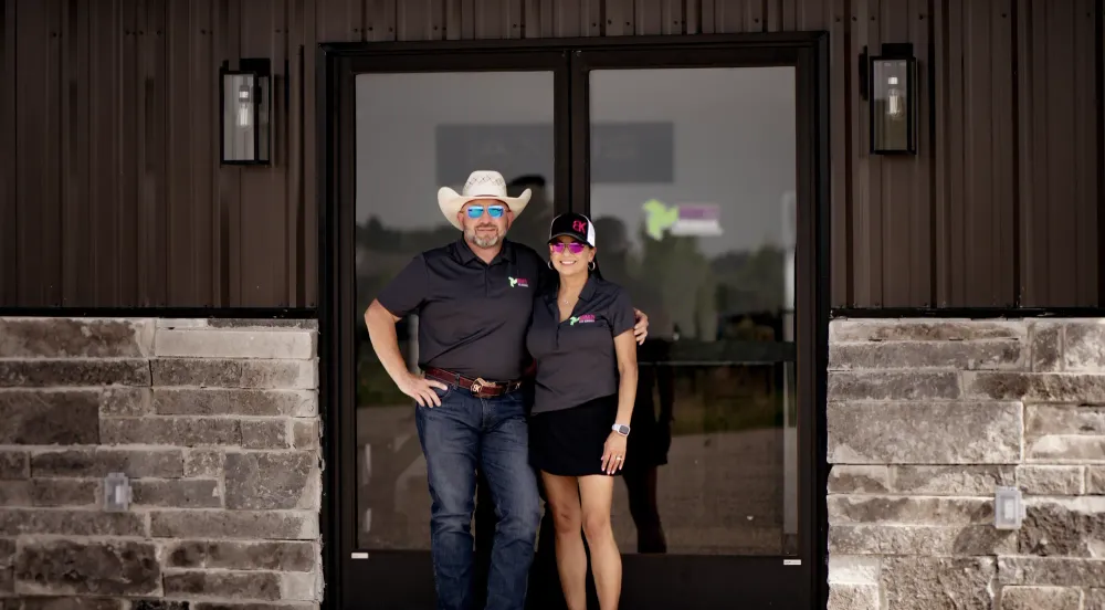 A man and a woman are standing in front of a building.