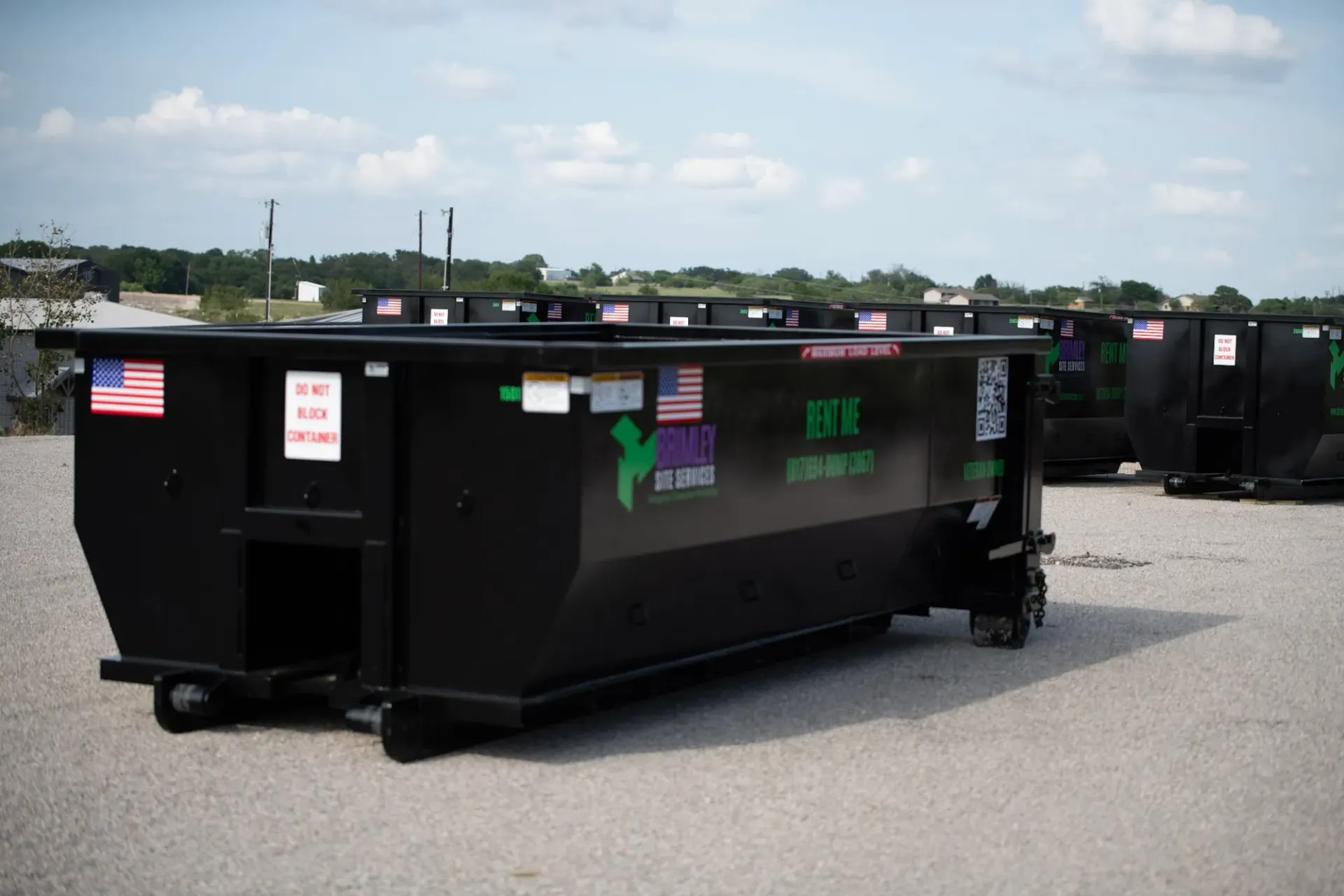 A large black dumpster with the letters etm on it