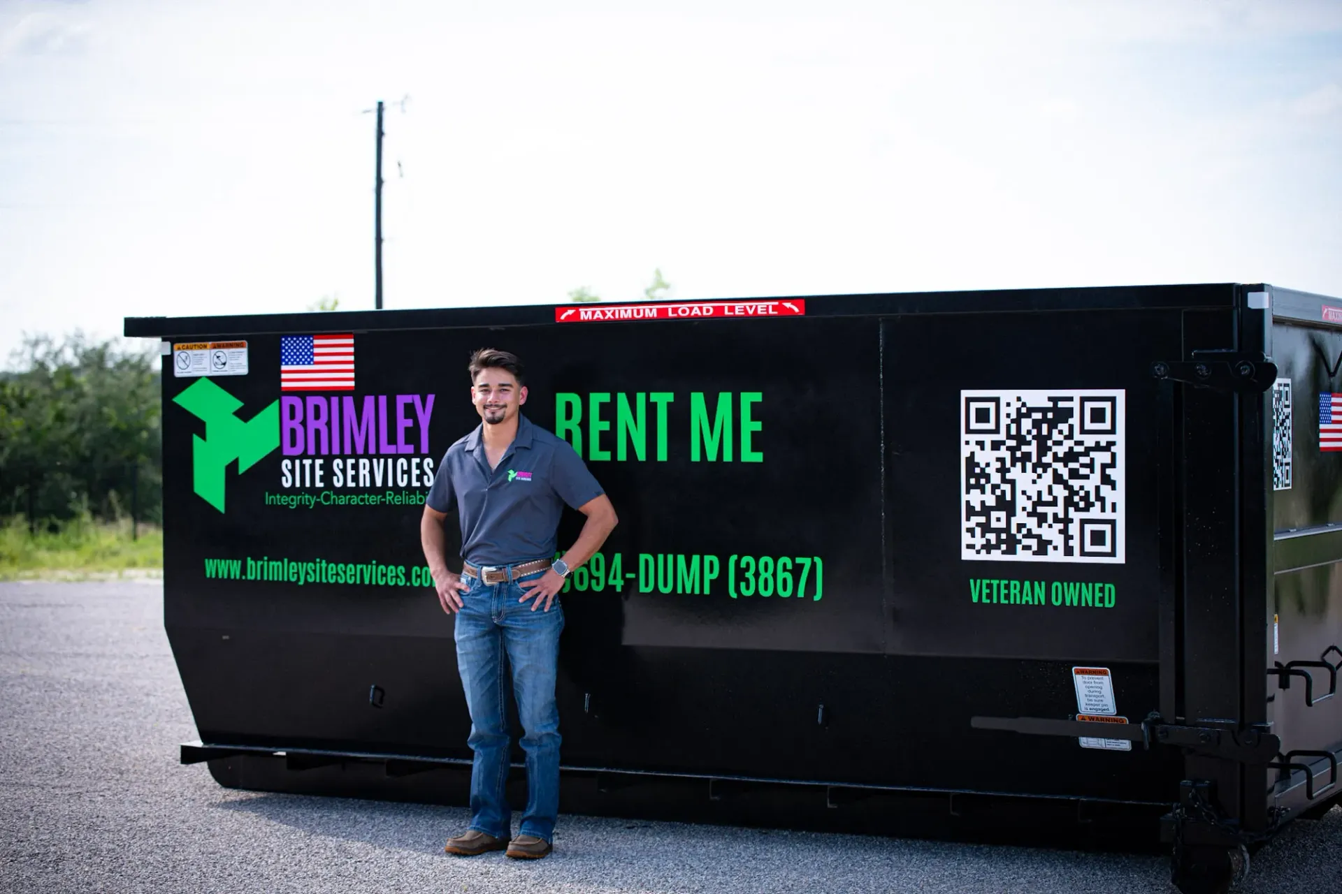 A man is standing in front of a dumpster that says `` rent me ''.
