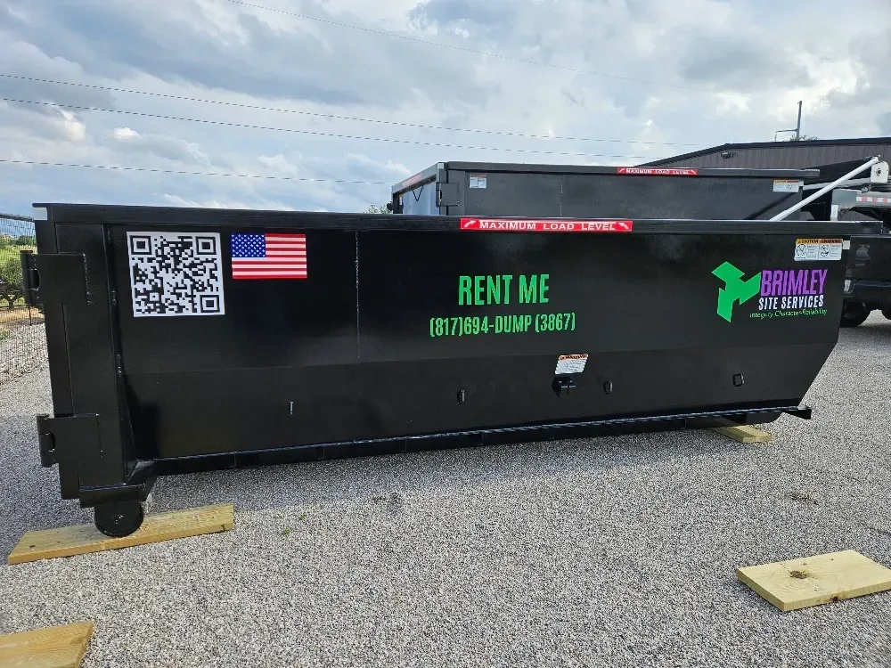 A dumpster is parked in front of a best buy store.