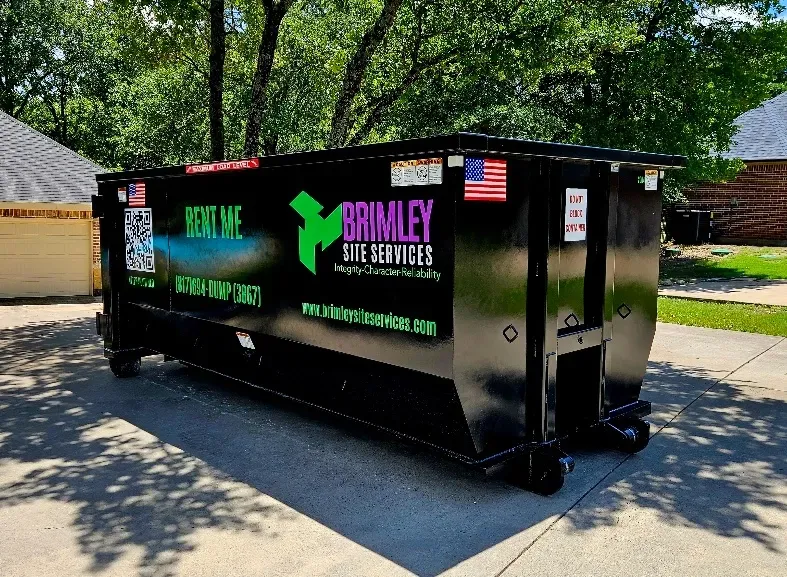 A dumpster with the word brialey on the side is parked in a driveway.