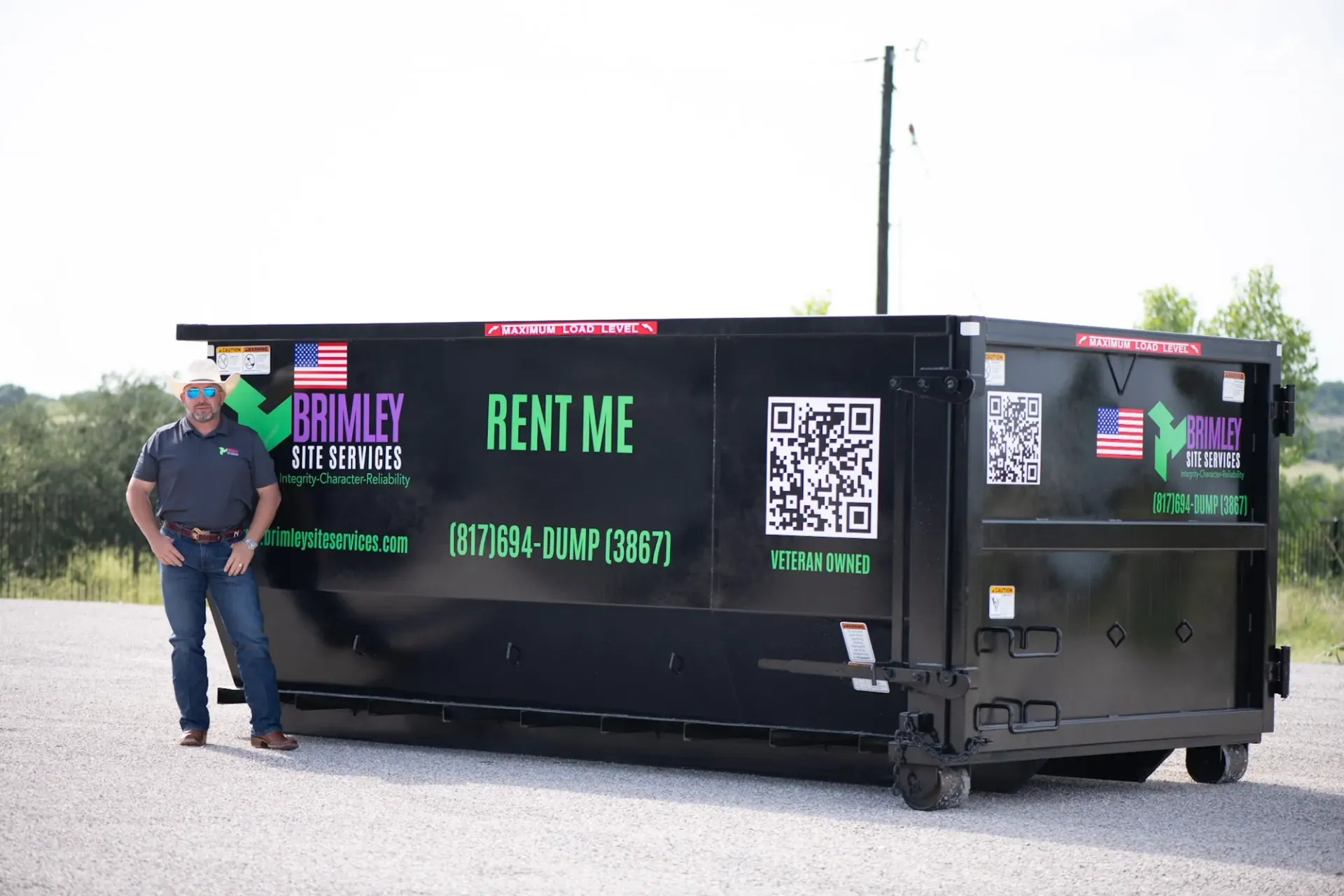 A dumpster is parked in the snow in front of a house.