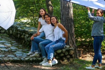 Three young people outdoors during a sunny day photo shoot using light modifyers