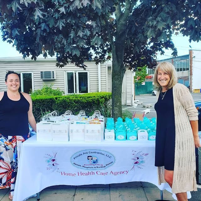Two women standing in front of a table that says home health care agency