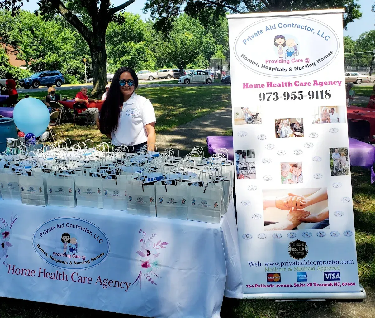 A woman stands in front of a table with a banner that says home health care agency