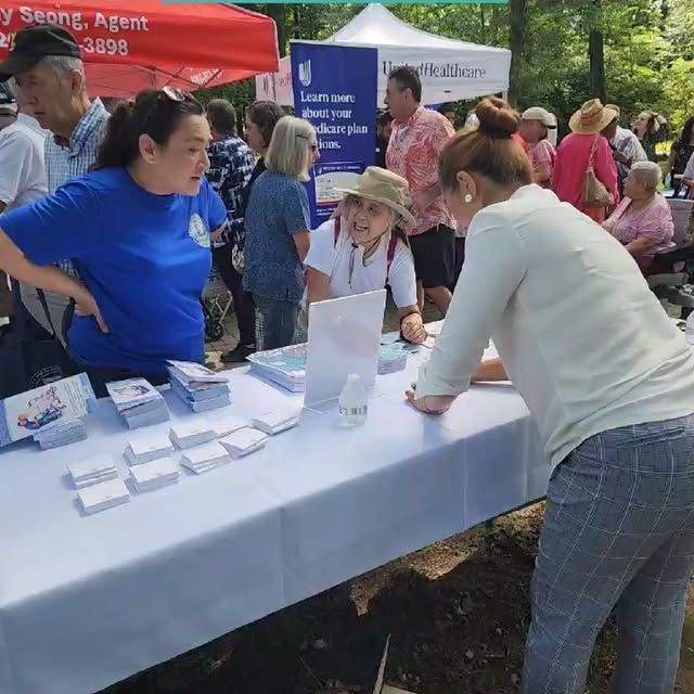 A group of people are gathered around a table with a sign that says ' agent ' on it