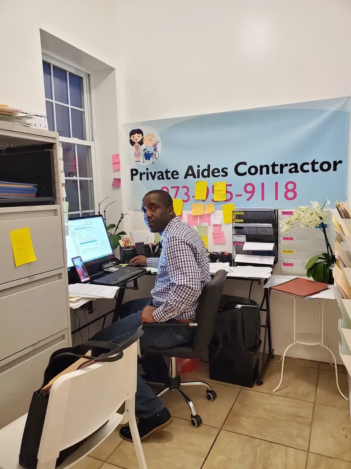 A man is sitting at a desk in front of a computer.