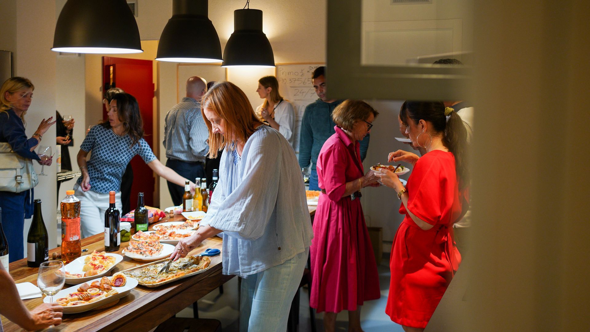 Persone a una festa con del cibo sul tavolo; riunione al chiuso.