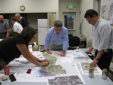 People gathered around a table reviewing documents in a planning meeting