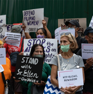Protesters with signs demonstrating against attacks on human rights, with signs.