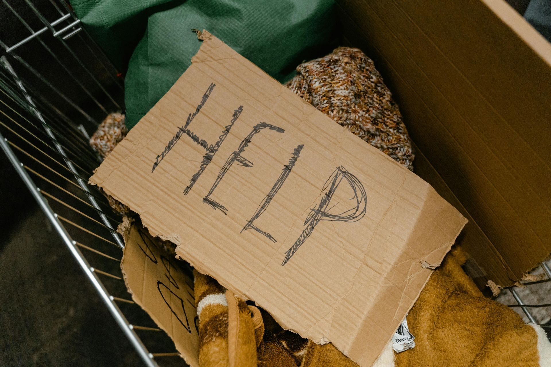 A cardboard sign with the word help written on it