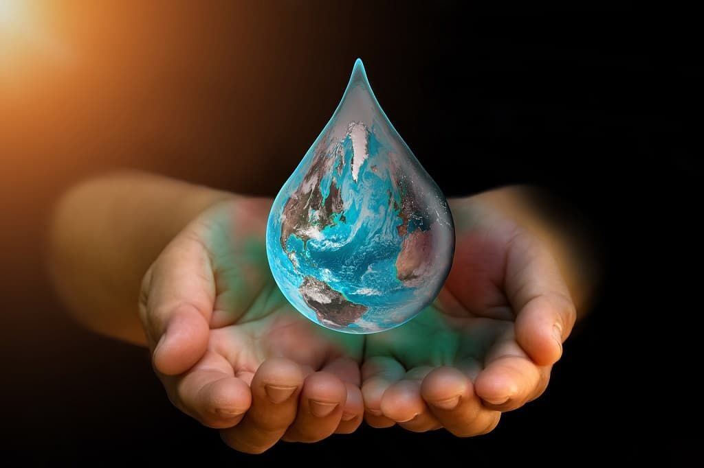 Cupped hands accept an enlarged drop of water