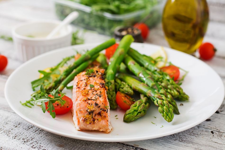 A white plate topped with salmon , asparagus and tomatoes.coming soon