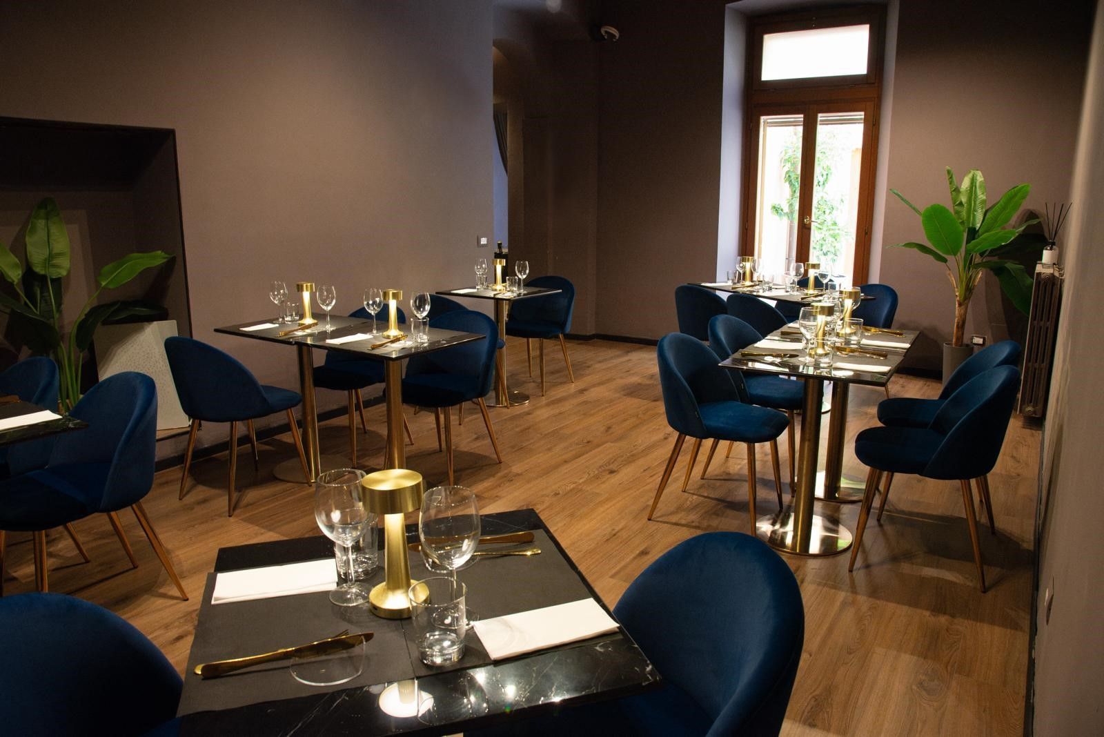 Una sala da pranzo con tavoli e sedie e una finestra.