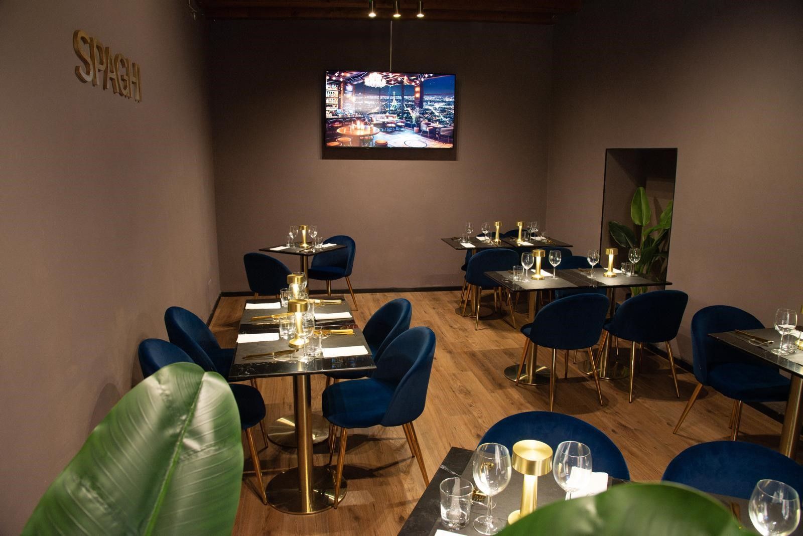 Un ristorante con tavoli e sedie e un televisore a parete.