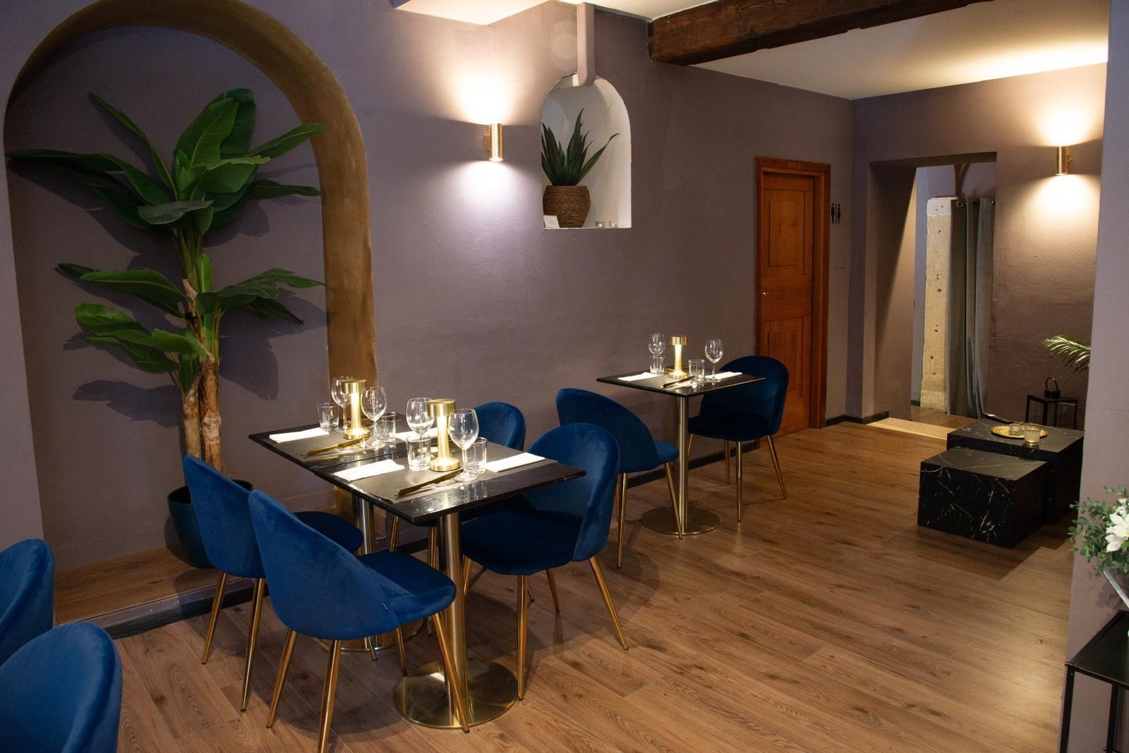 Una sala da pranzo con tavoli e sedie e una pianta.