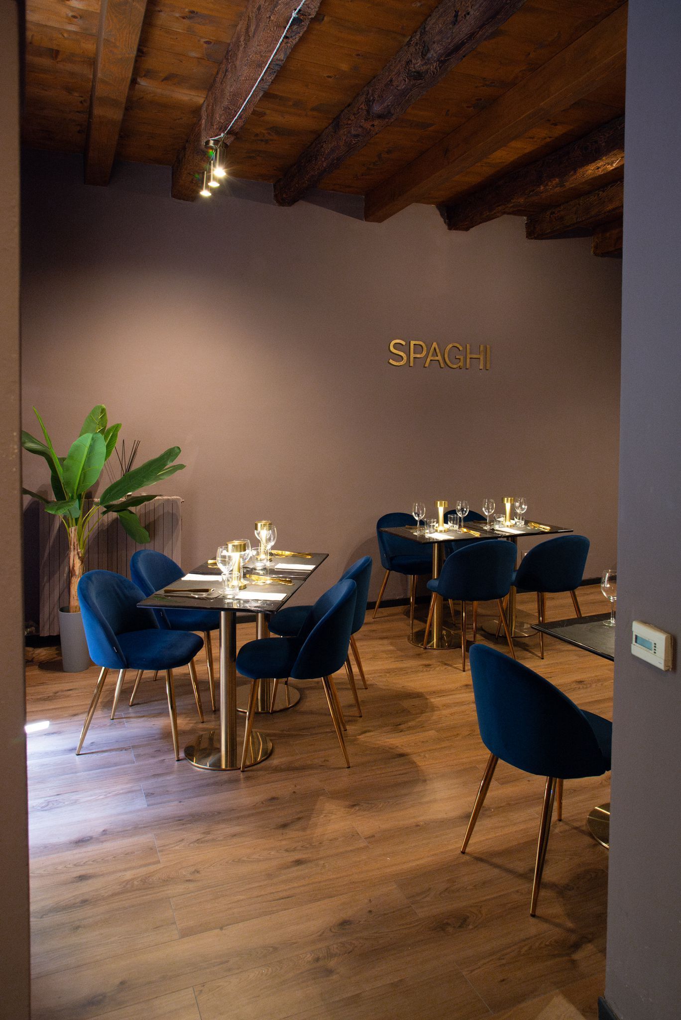 Una sala da pranzo con tavoli e sedie e una pianta.