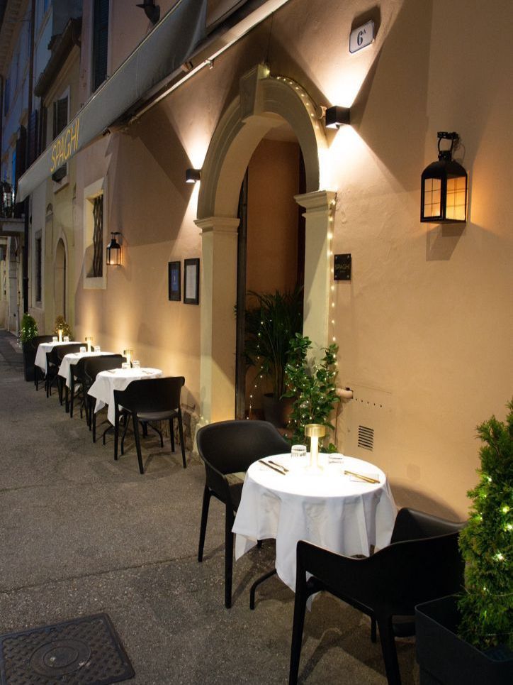 Una fila di tavoli e sedie all'esterno di un ristorante