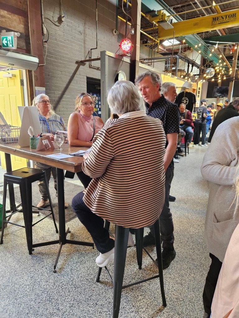 A coffee mug that says cozy winter vibes is on a wooden table.