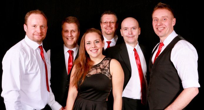 A group of people in suits and ties are posing for a picture.