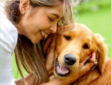 Smiling Woman Hugging Dog In A Garden