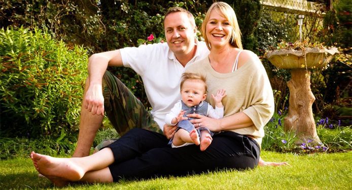 Portrait of a couple with their child in a garden