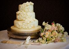 A wedding cake and a bouquet of flowers are on a table.