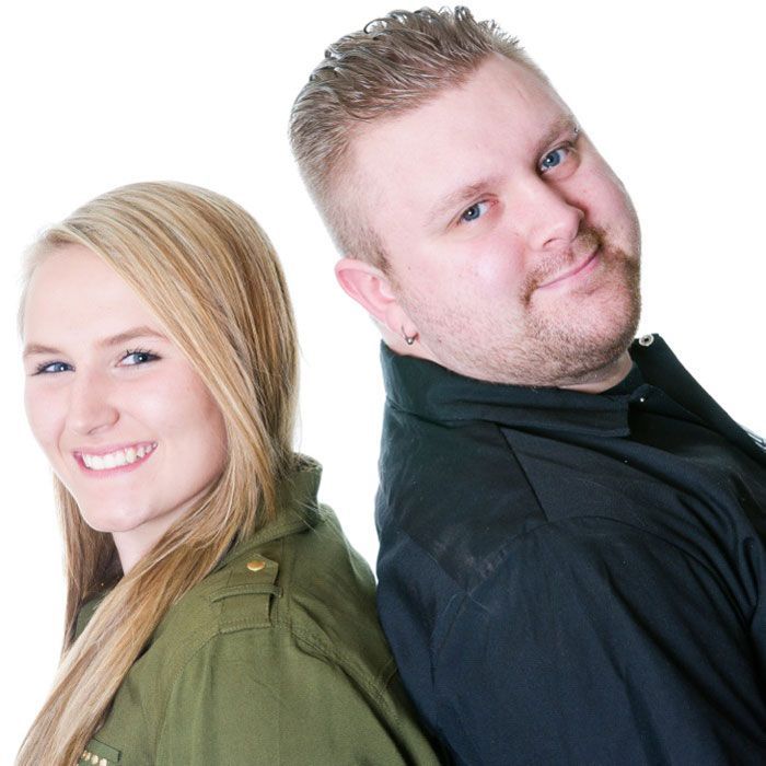 A man and a woman are standing back to back and smiling