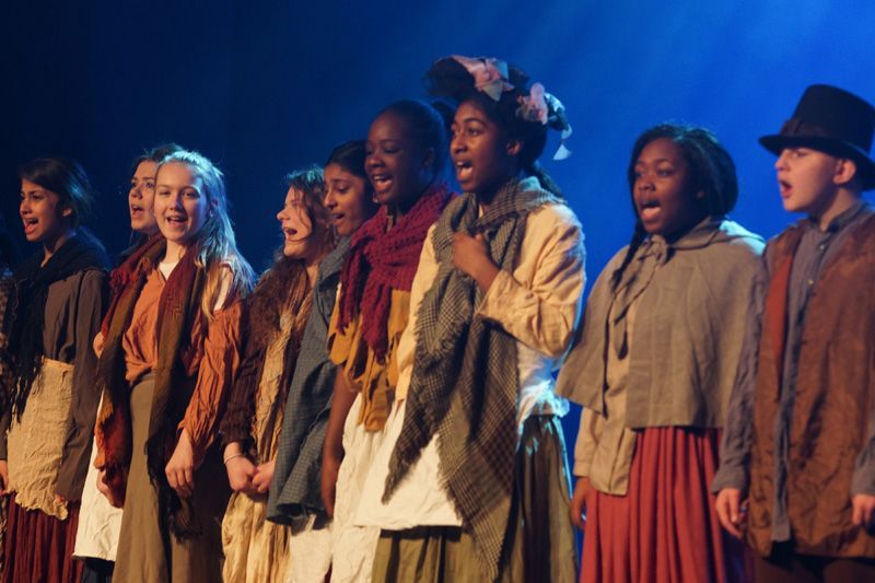 A group of children are singing on a stage