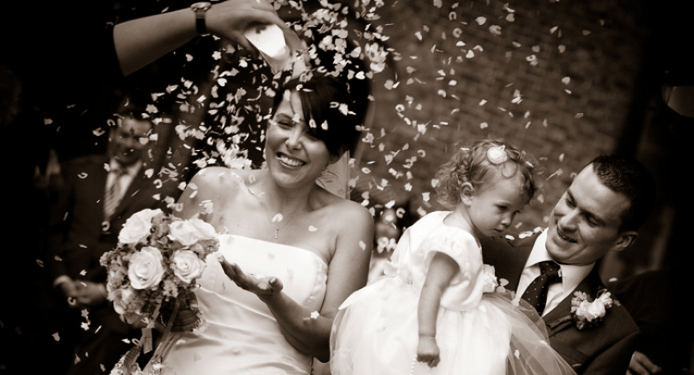 A bride and groom are being showered with confetti at their wedding