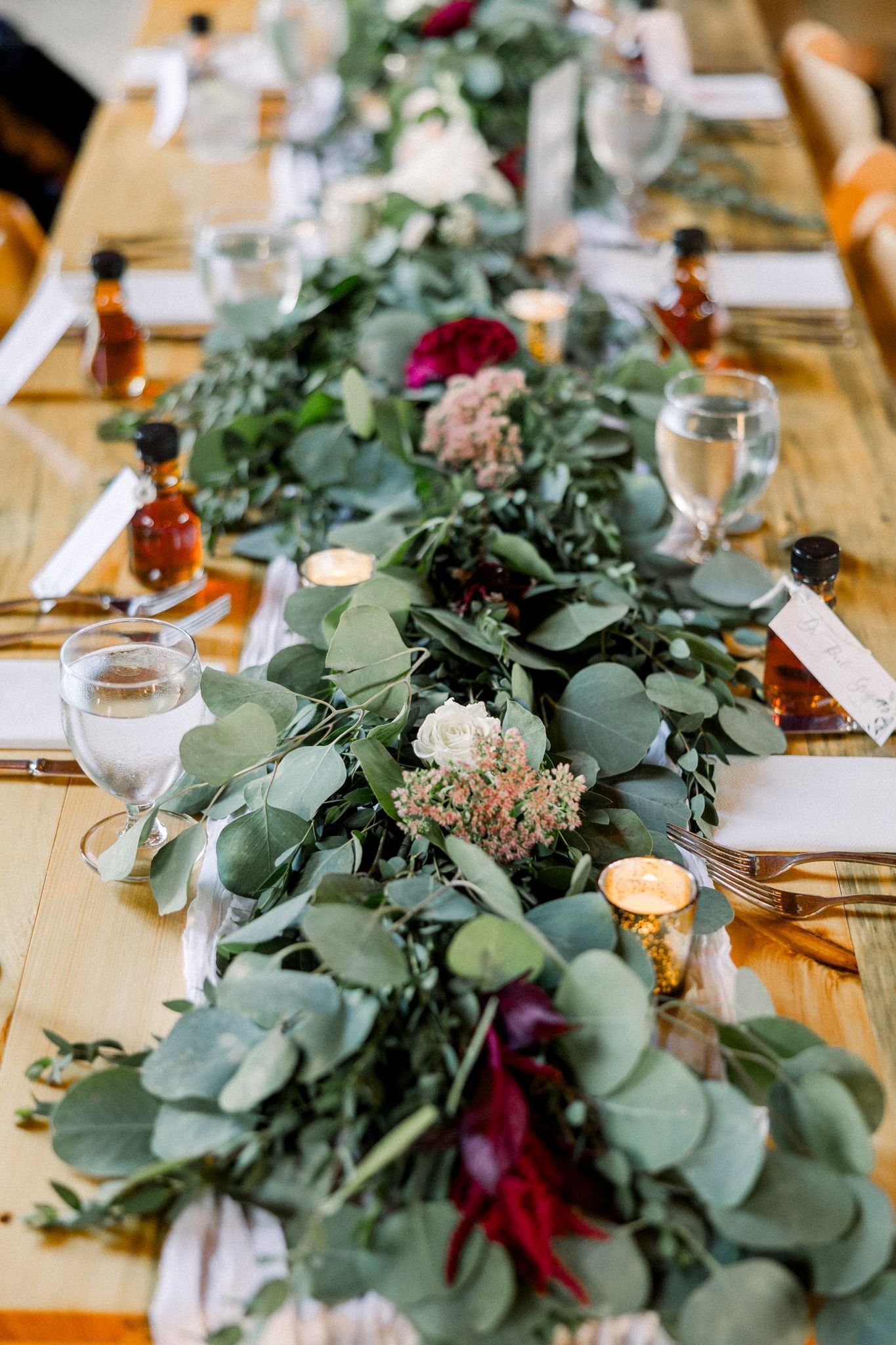 up close image of wedding floral display on reception table in isham family farm event barn
