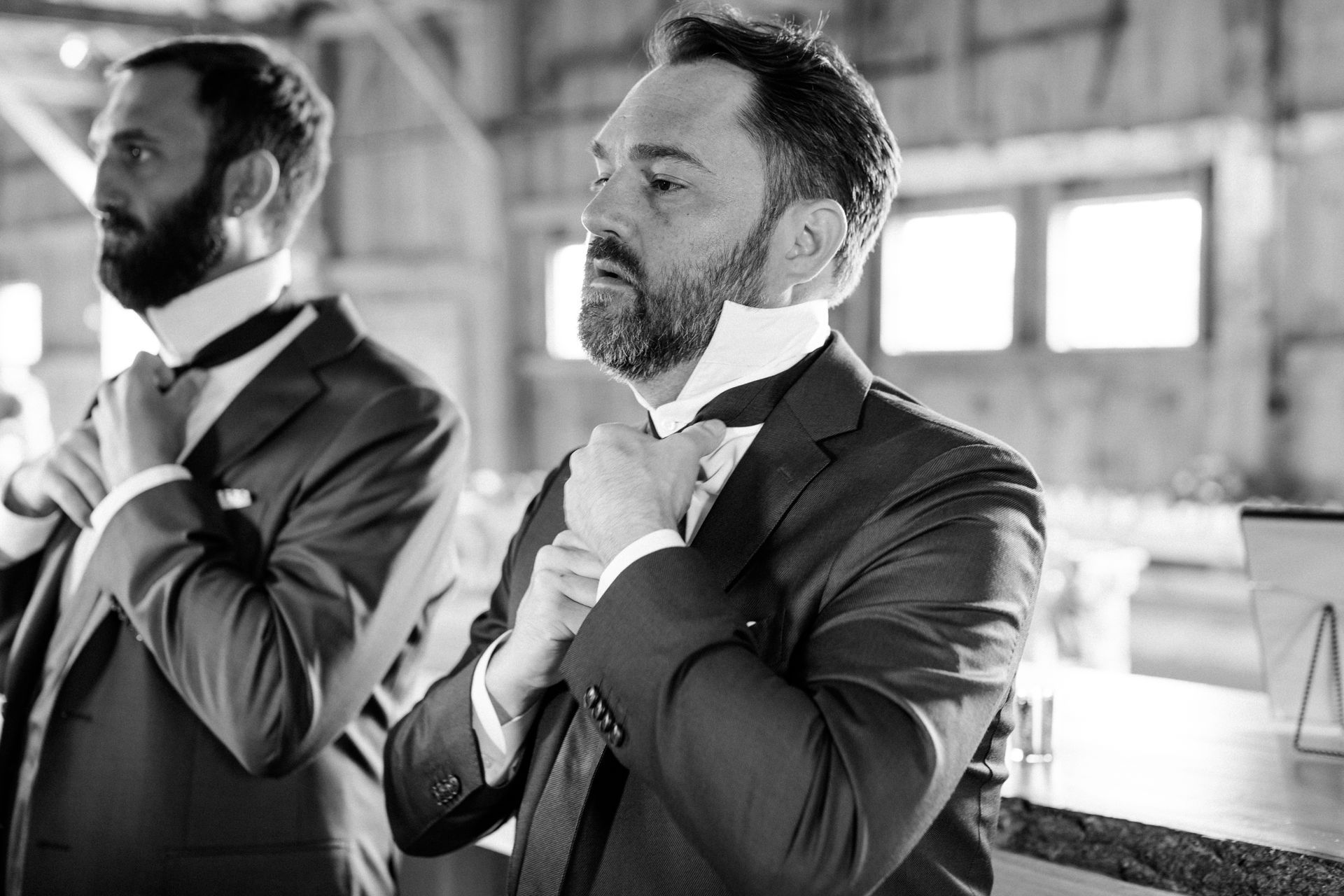 black and white photo of groom preparing for his nuptials at isham family farm in vermont