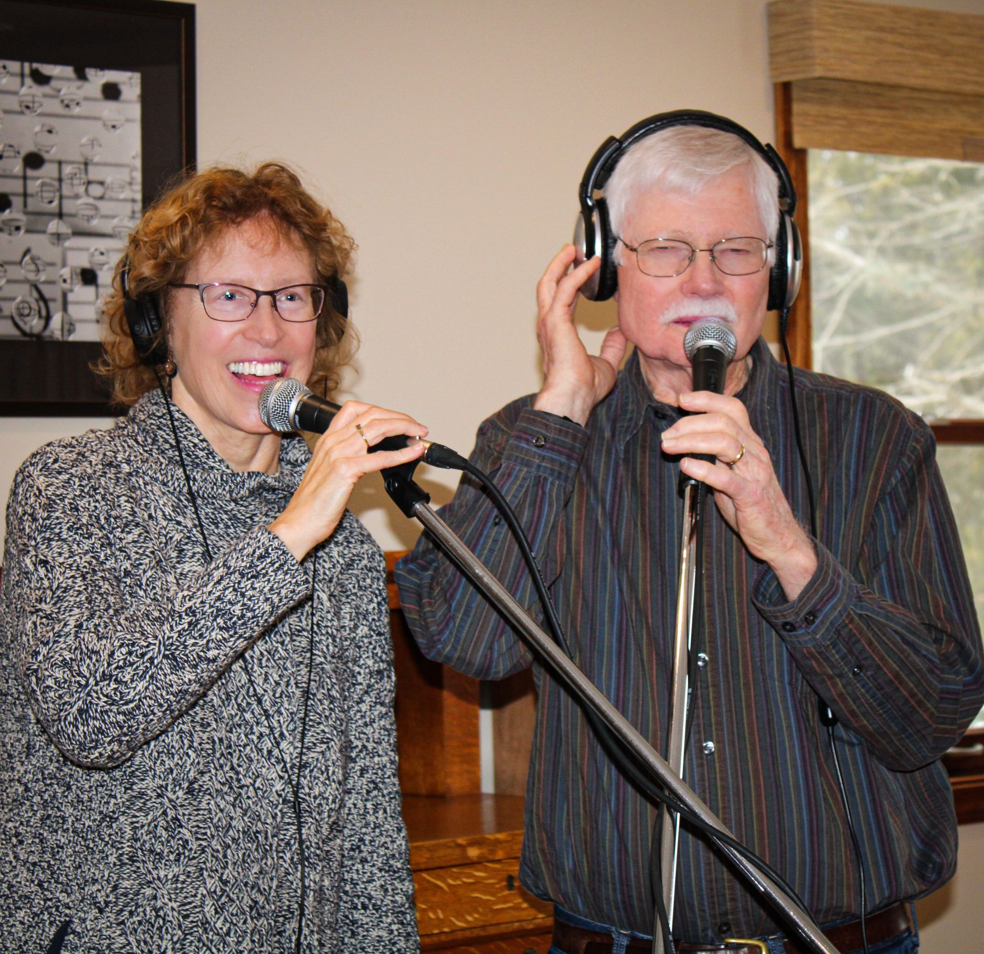 Two men harmonizing with headphones on  performing at isham family farm