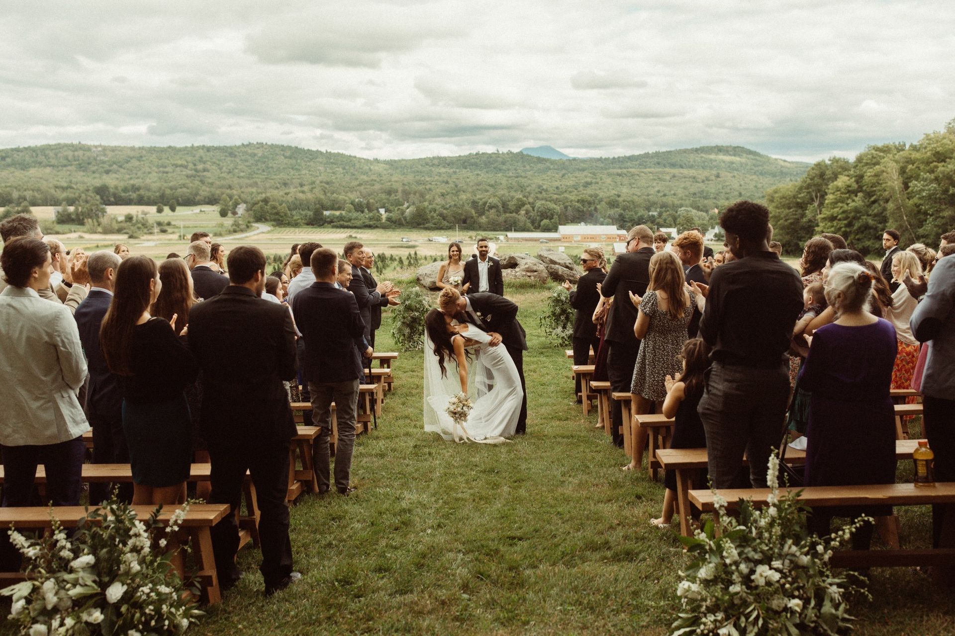 a groom dipping and kissing his new bride after their wedding ceremony at isham family farm in vermont
