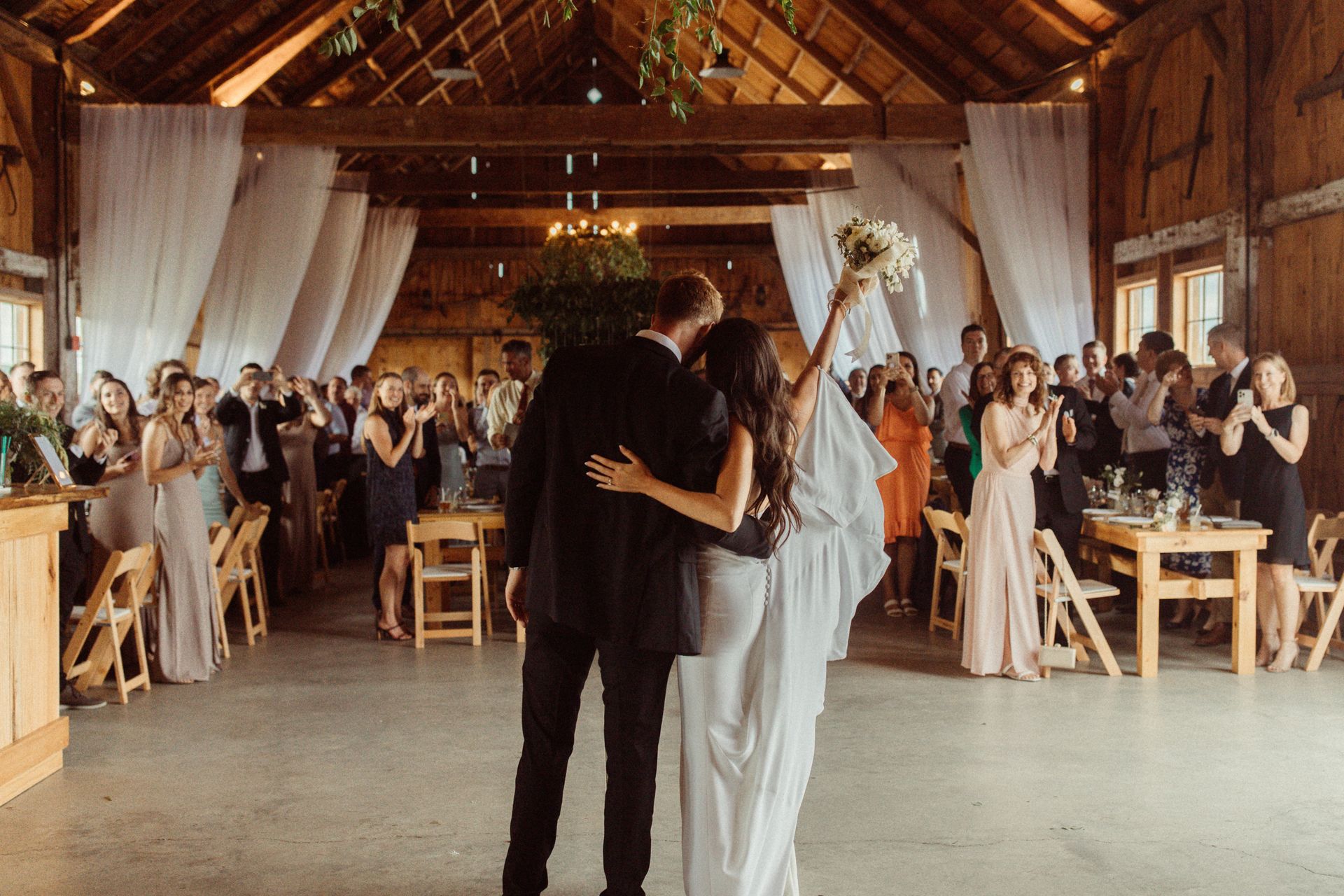 bride and groom facing their wedding guests celebrating after their announcement