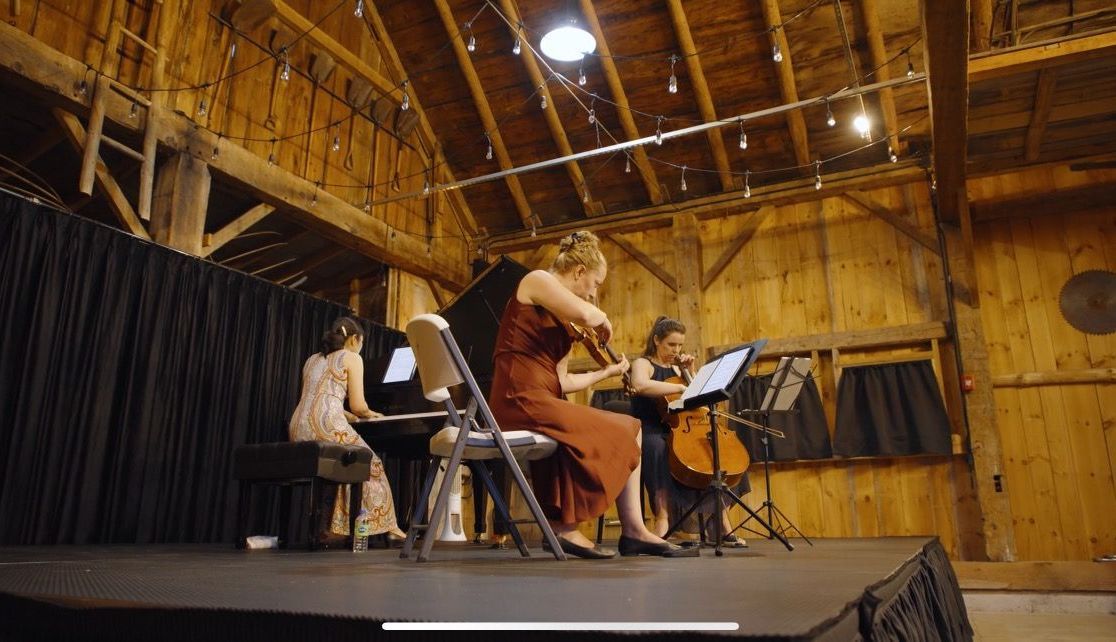 string band with piano performing on the events barn stage at isham family farm 